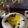 Moringa pancakes with honey drizzling over them